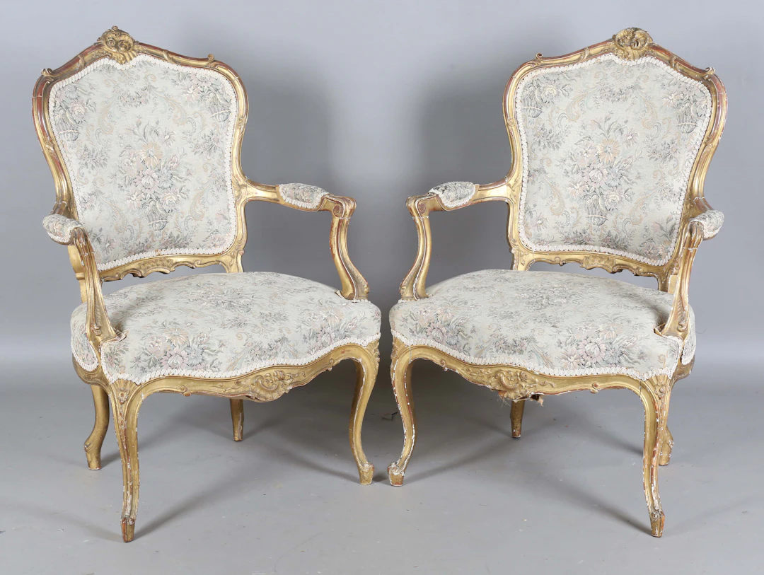 A pair of early 20th century French giltwood showframe fauteuil armchairs