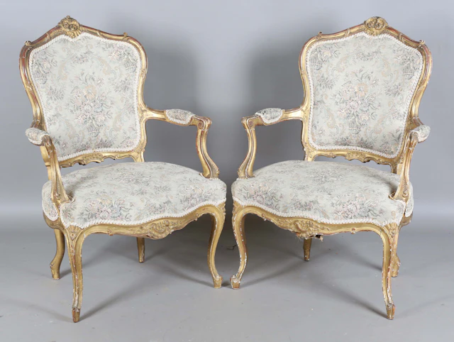 A pair of early 20th century French giltwood showframe fauteuil armchairs