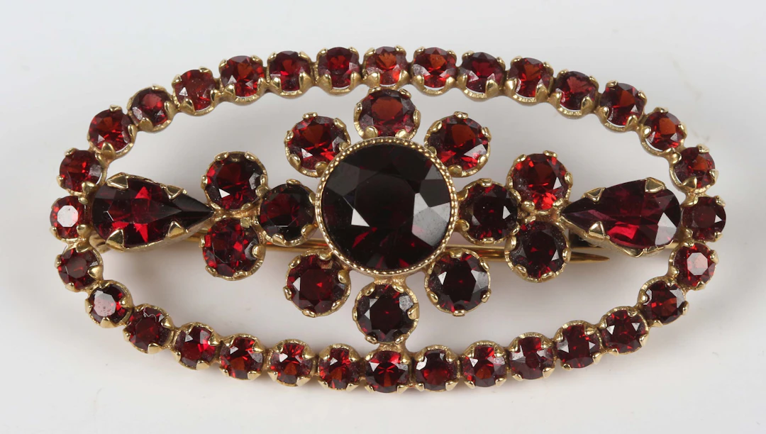 A gold and Bohemian garnet brooch of oval openwork form with a central