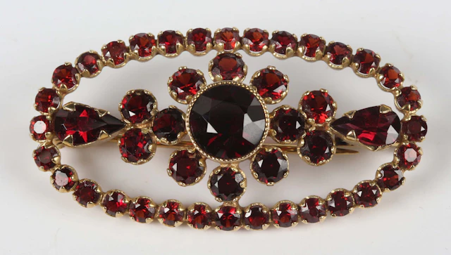 A gold and Bohemian garnet brooch of oval openwork form with a central