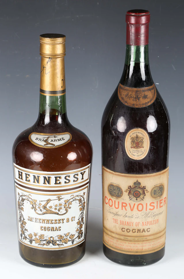 Two oversized retailer's advertising glass bottles of Hennesey and