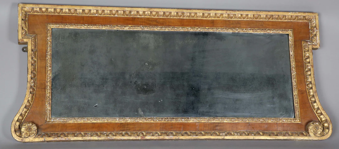 A George II walnut and giltwood wall mirror of shaped form, the frame