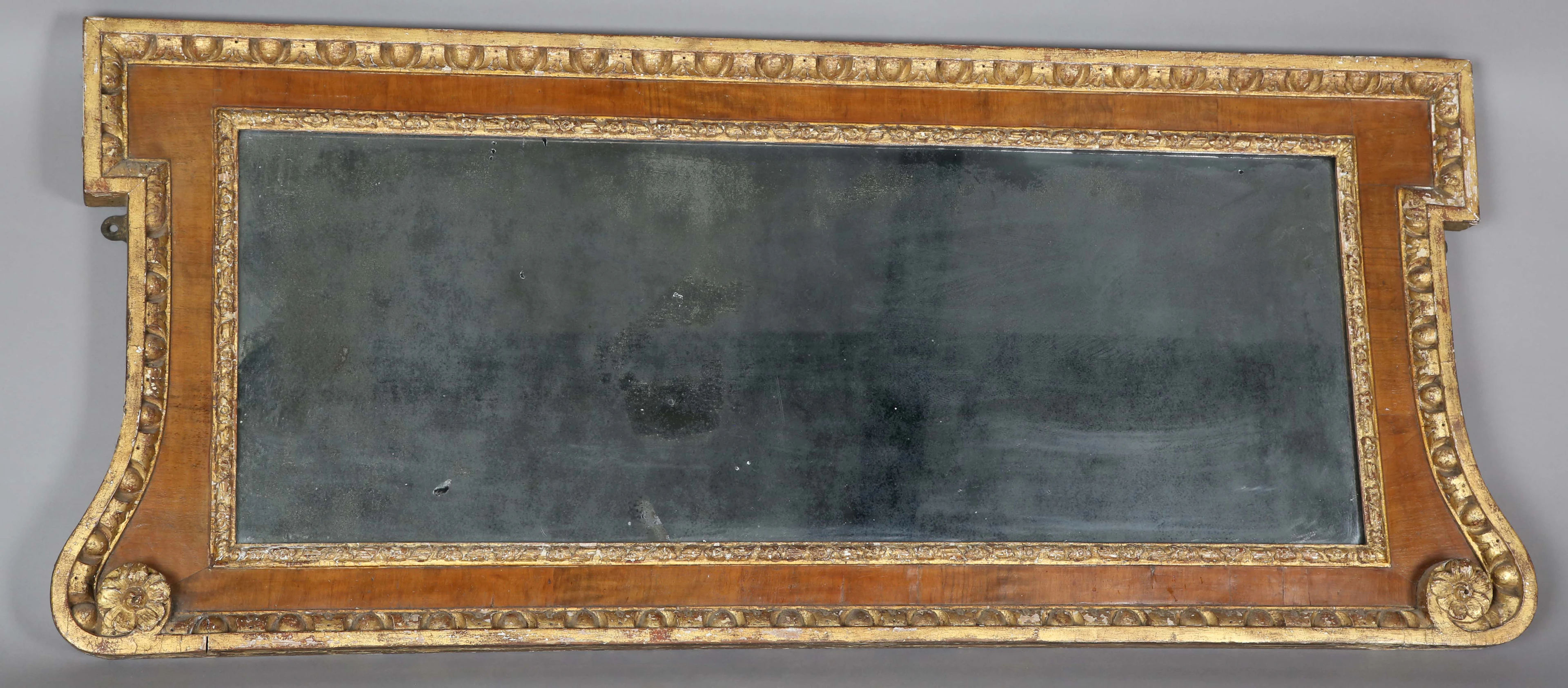 A George II walnut and giltwood wall mirror of shaped form, the frame