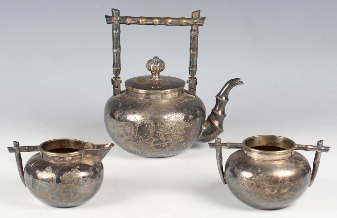 A late 19th century japonaiserie silver plated three-piece tea set