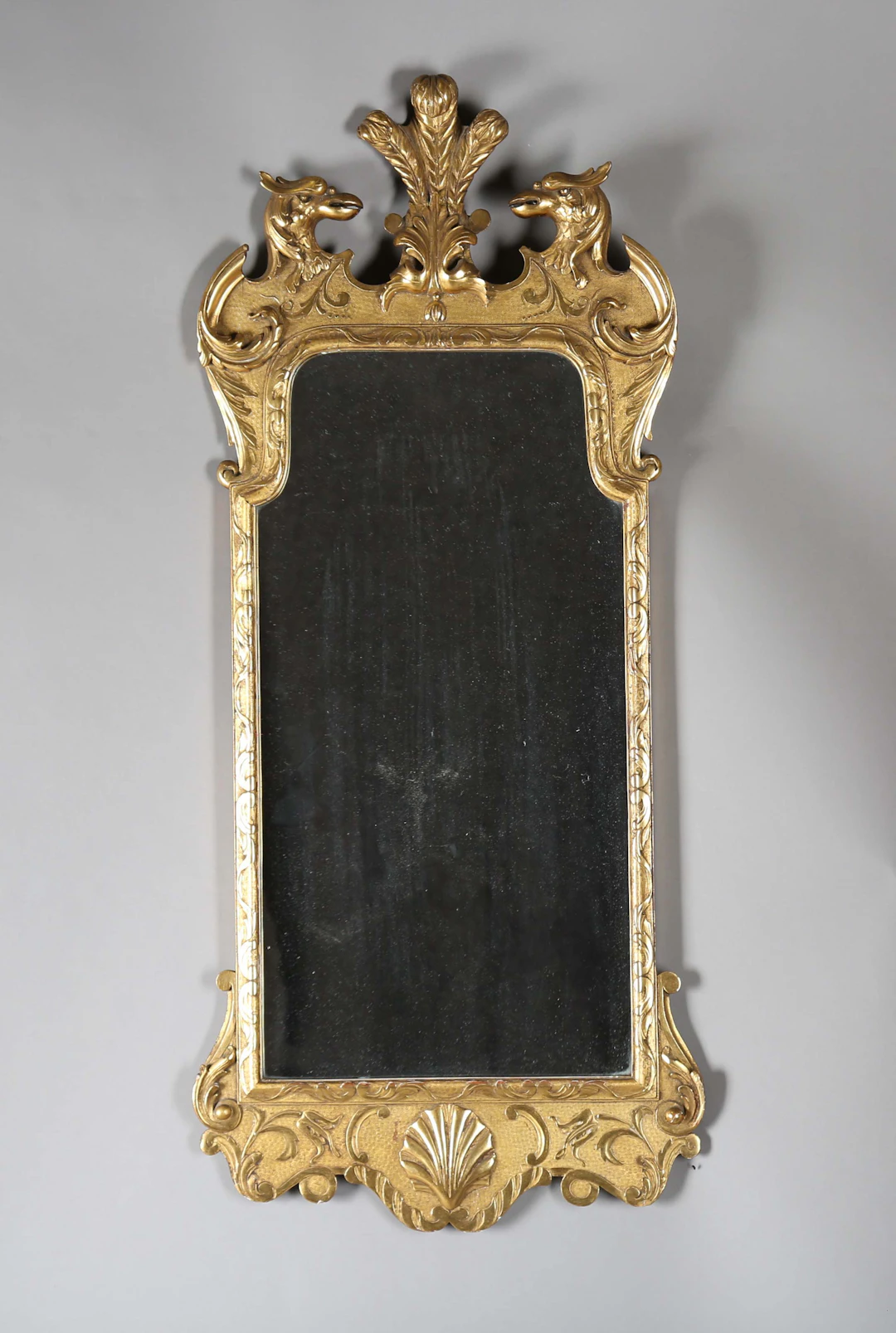 A 20th century George I style giltwood wall mirror, the shaped frame
