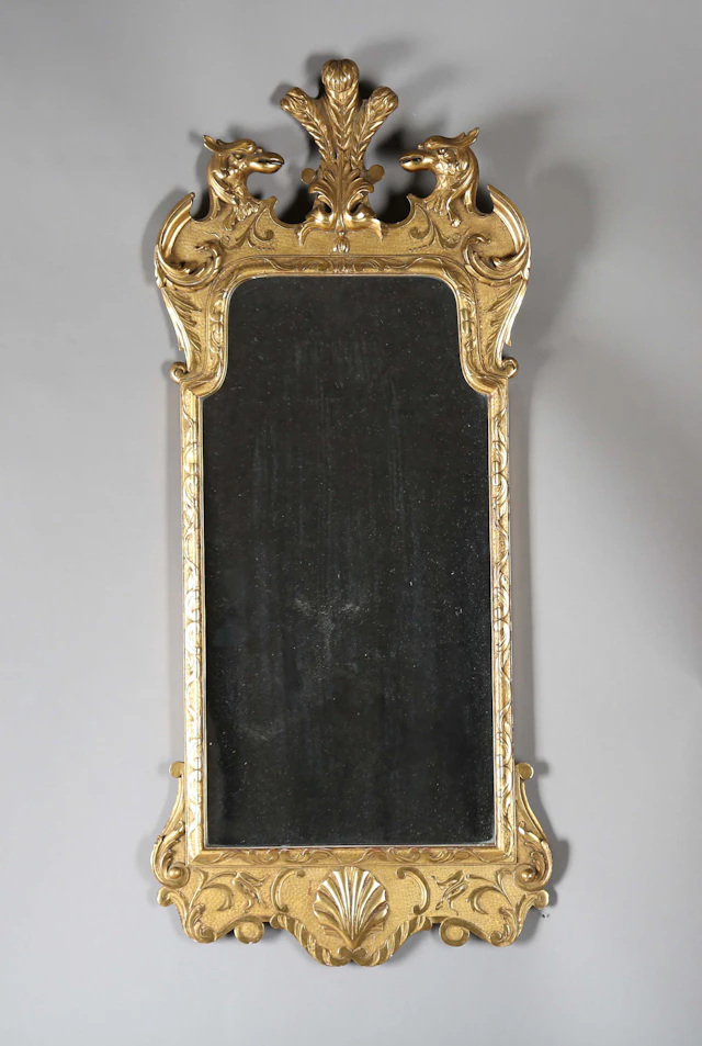 A 20th century George I style giltwood wall mirror, the shaped frame