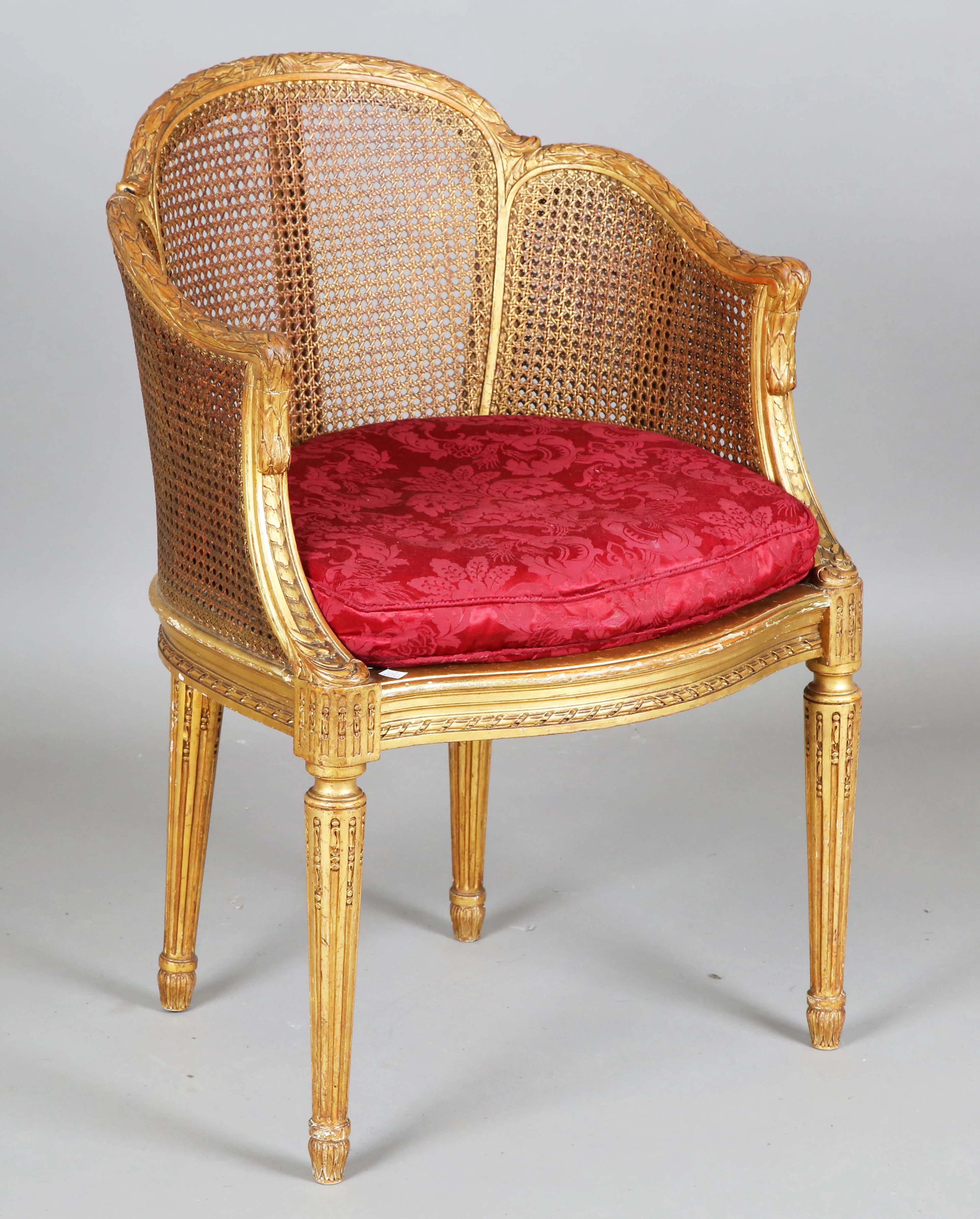An early 20th century French giltwood framed tub back armchair, the