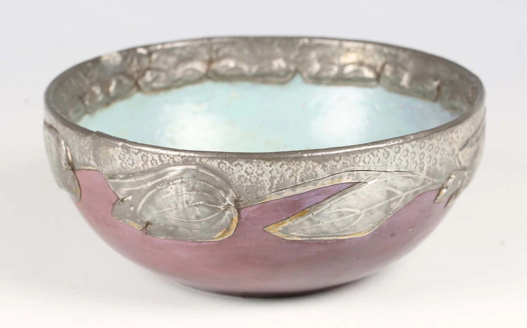 An Art Nouveau painted papier-mâché and pewter mounted bowl, the purple
