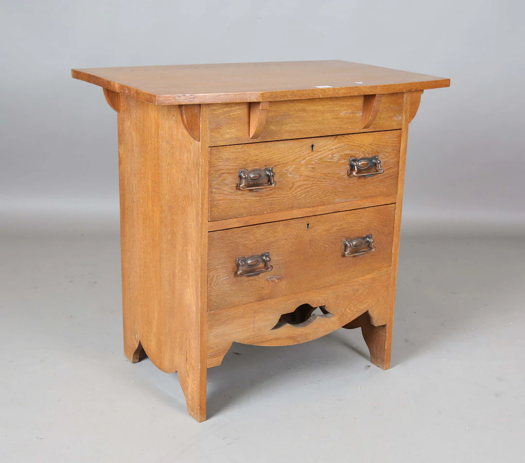 An early 20th century Arts and Crafts oak chest of two drawers with