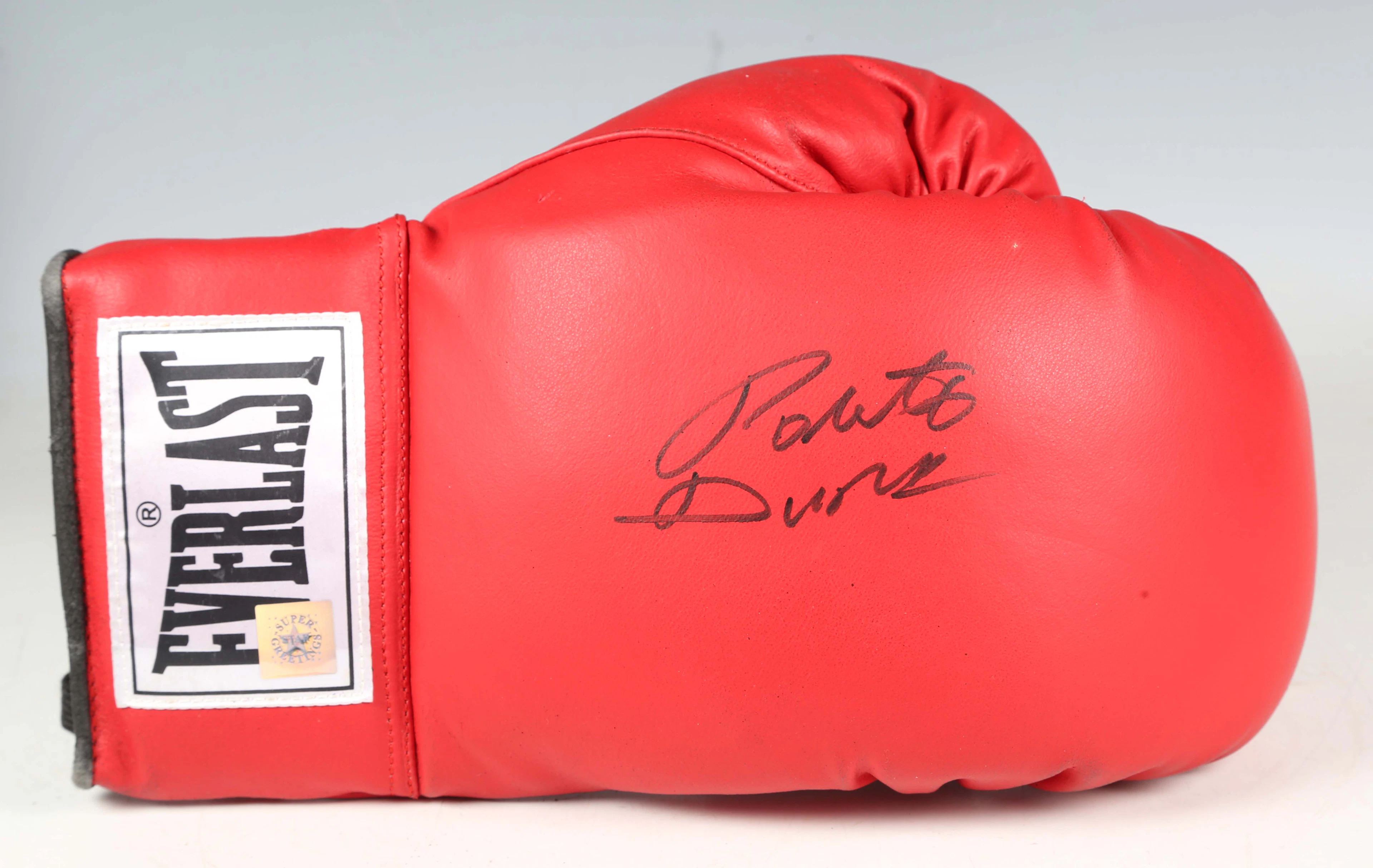 An Everlast red boxing glove, signed by Roberto Duran in black marker