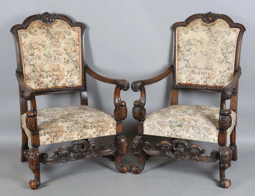 A pair of early 20th century Carolean Revival walnut framed armchairs