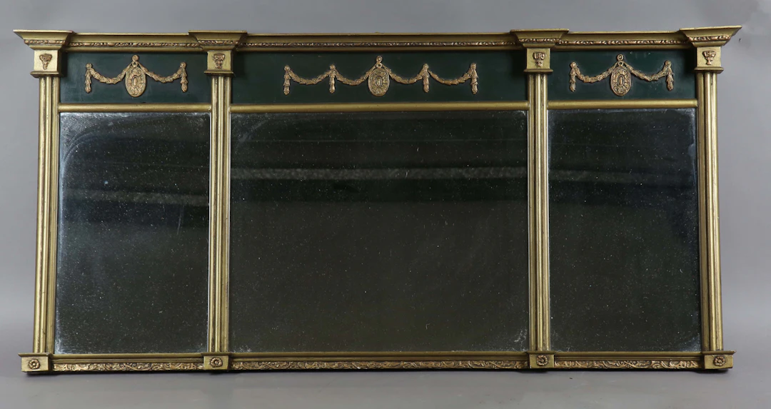 An early 20th century Regency style gilt and black painted overmantel