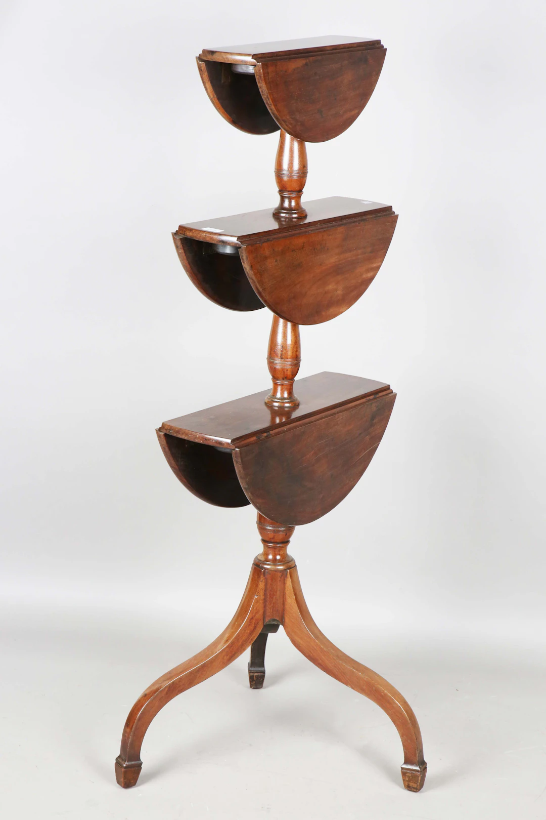 A late George III mahogany circular three-tier drop-flap dumb waiter