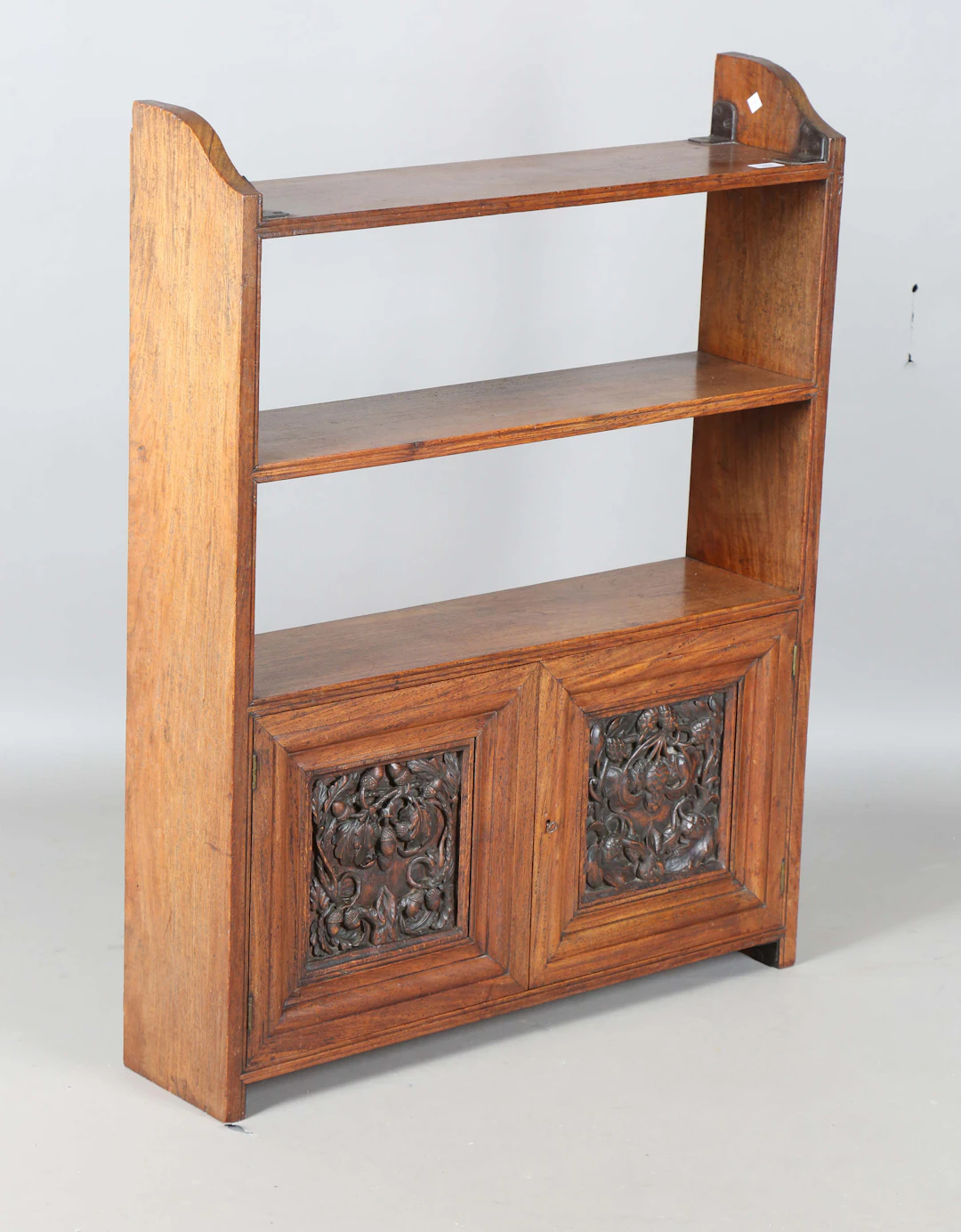 An Edwardian walnut bookshelf, fitted with two doors carved with acorns