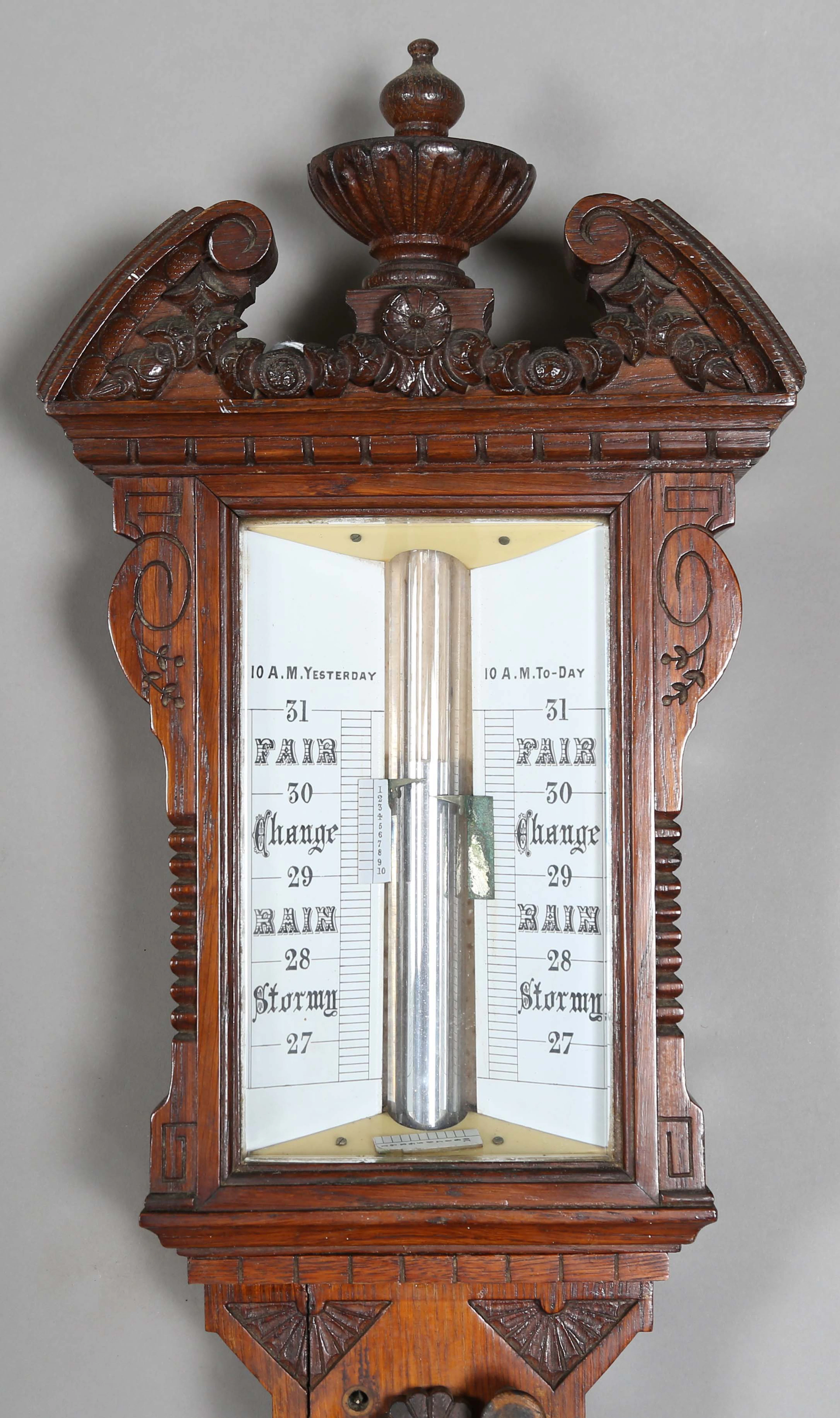 A late Victorian oak cased stick barometer, the white ceramic dial