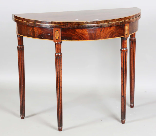 A George III mahogany demi-lune fold-over card table, the top crossbanded