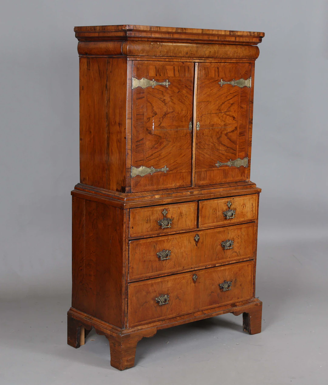 An early 18th century walnut collector's cabinet-on-chest, fitted