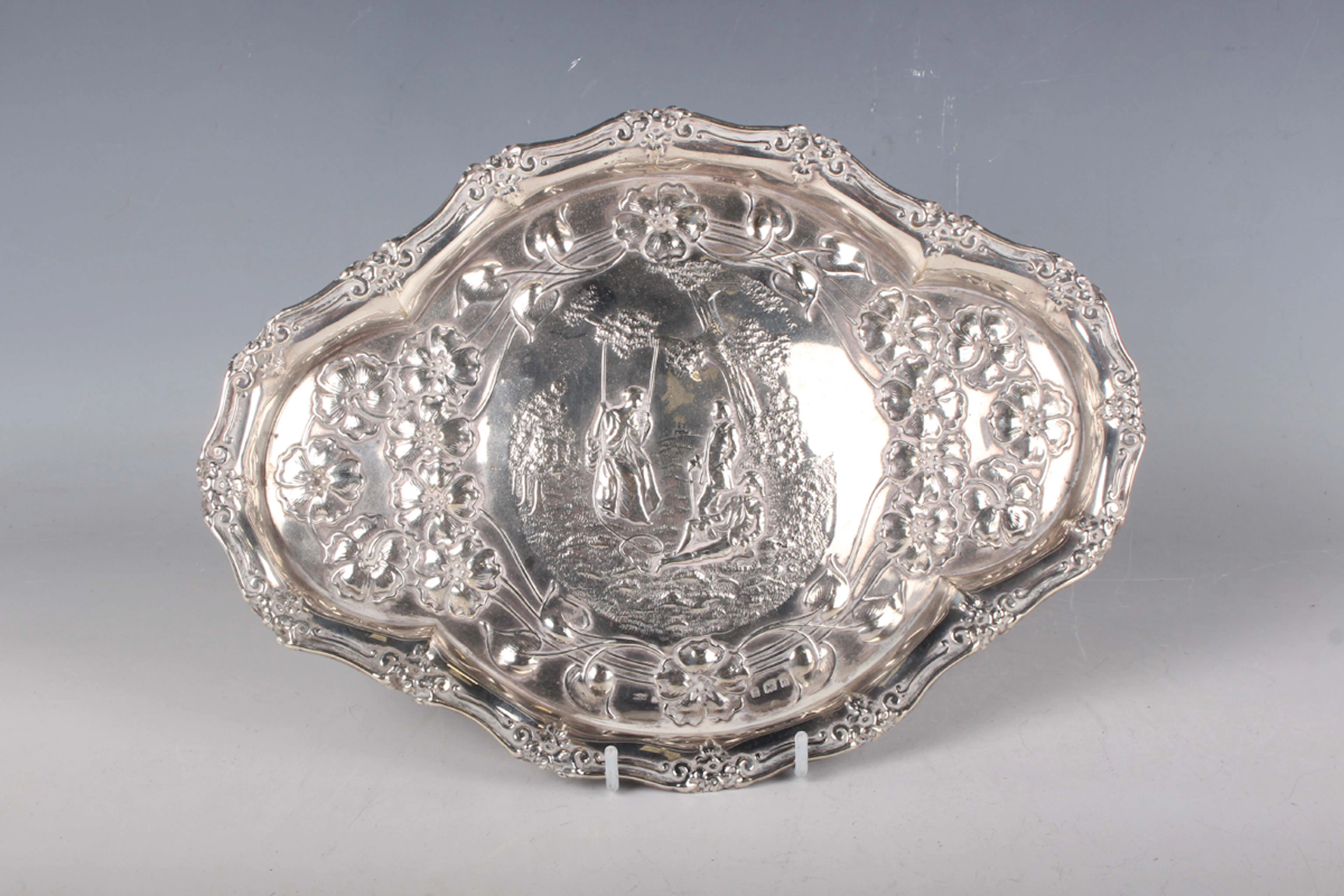 An Edwardian silver shaped oval dressing table tray, embossed with