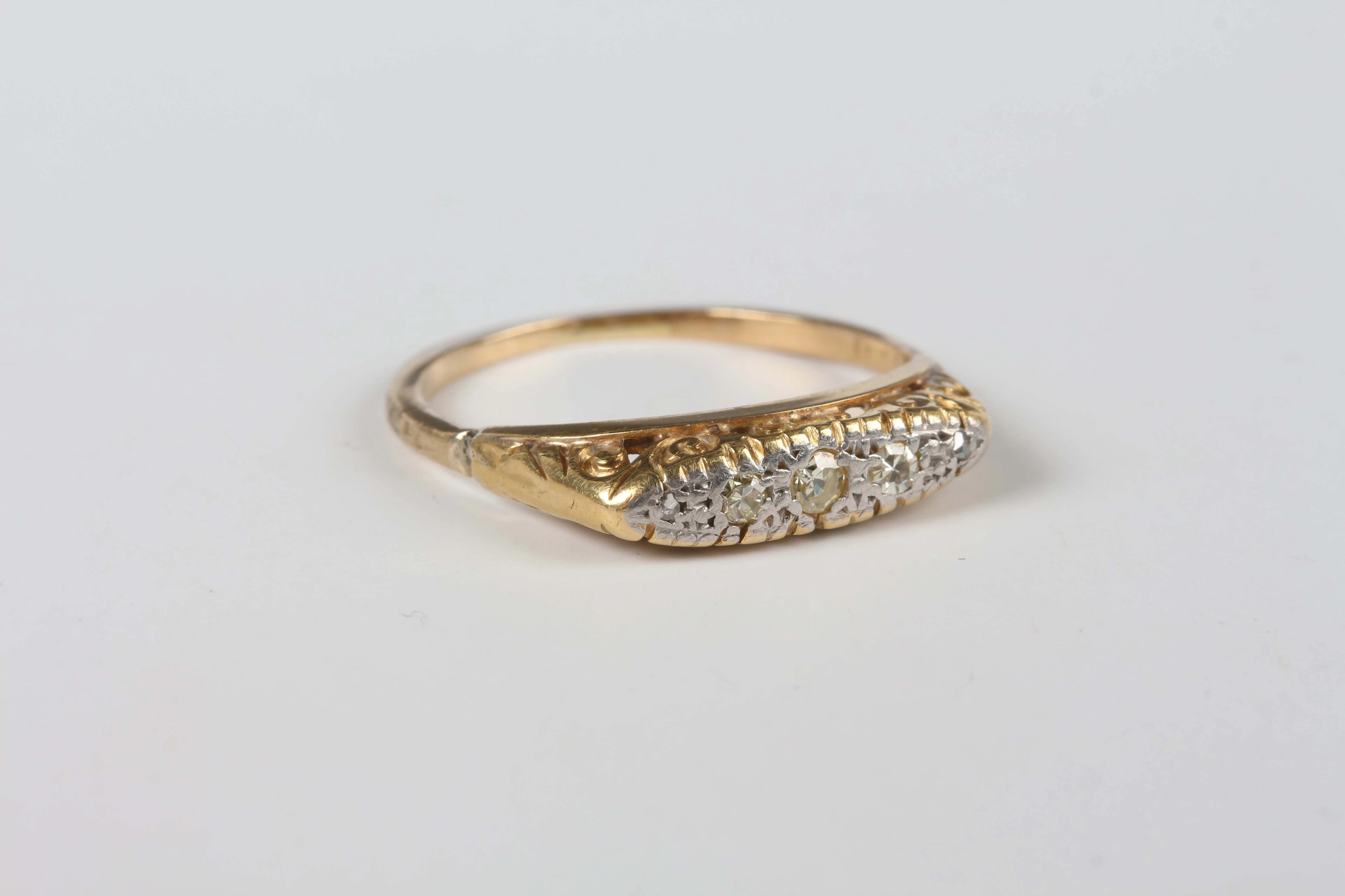 A gold and diamond five stone ring, mounted with a row of variously