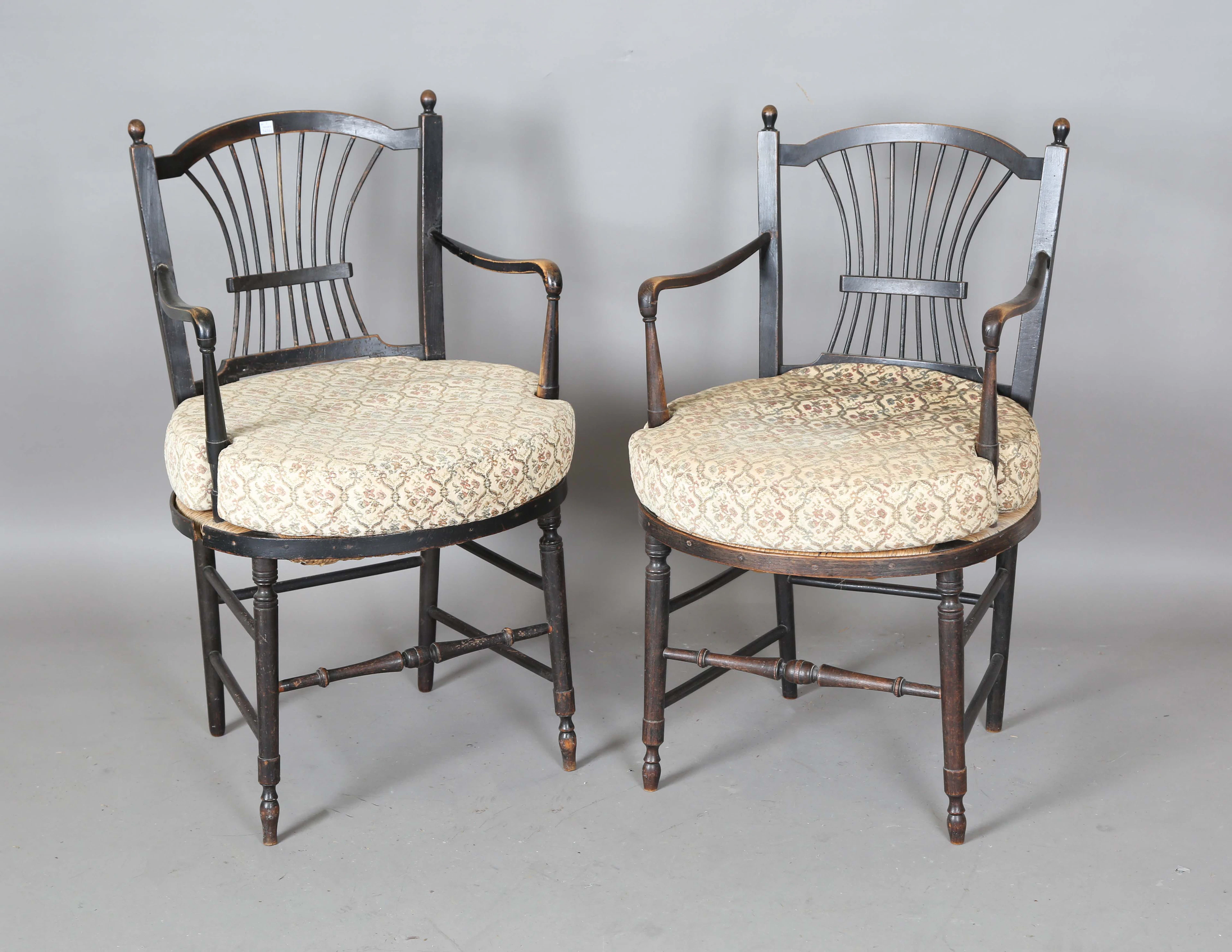 A very near pair of late Victorian 'Rossetti' Sussex armchairs by