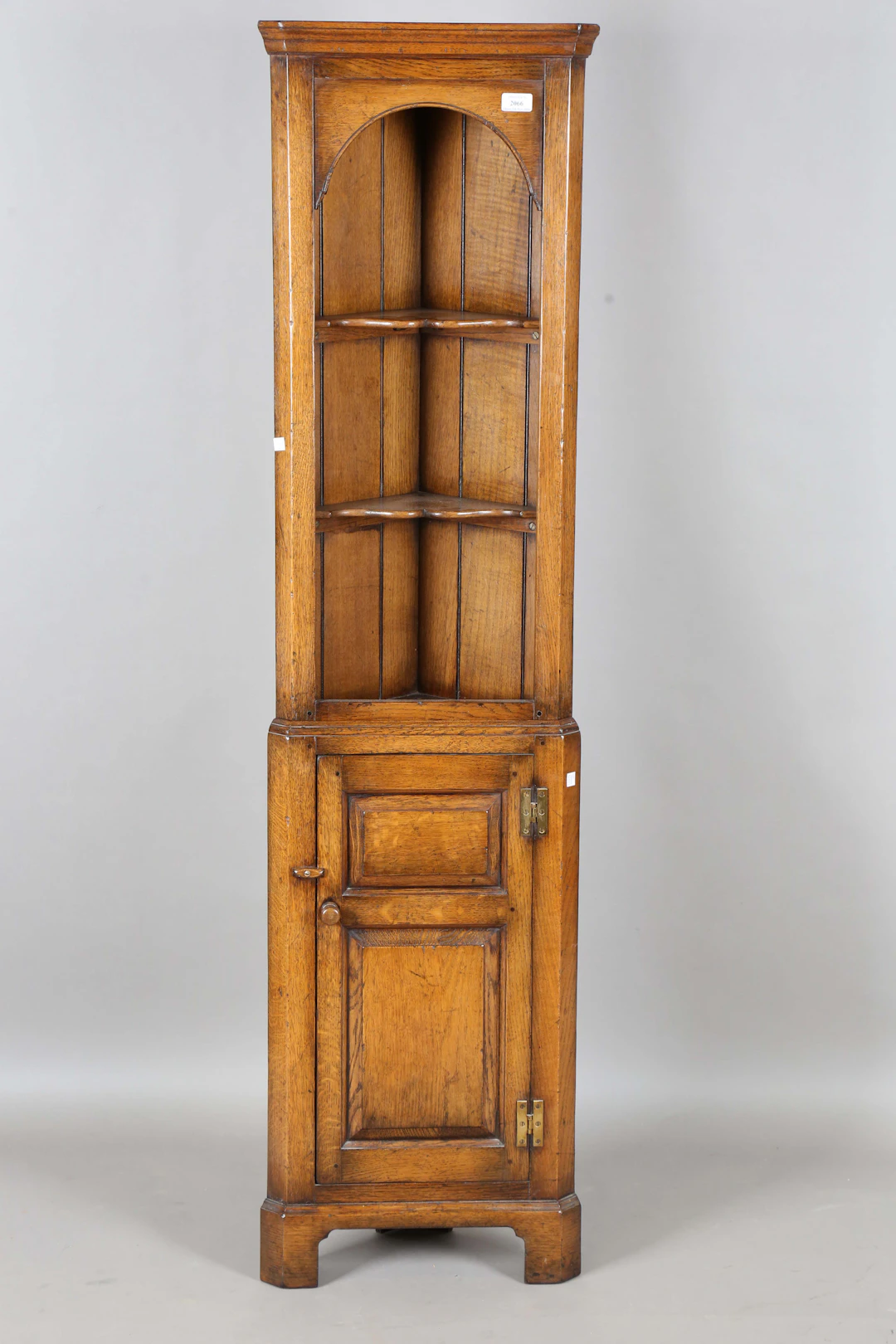 A late 20th century reproduction oak corner cabinet of small proportions