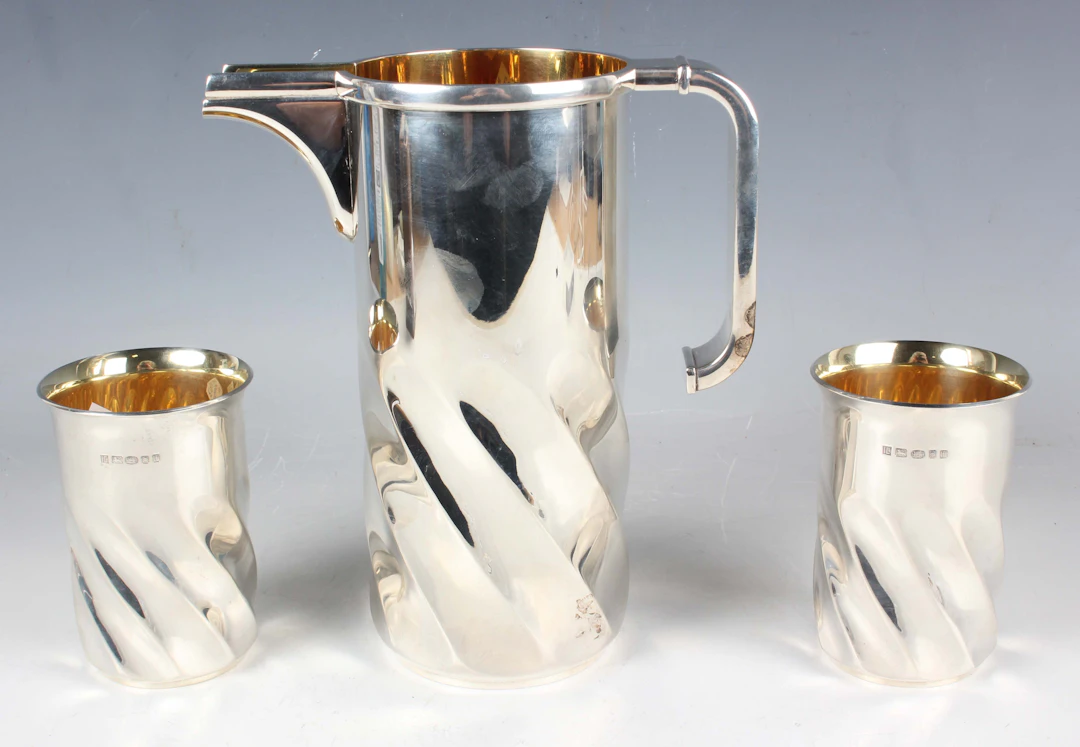 A Modernist silver water jug and two matching beakers, each of cylindrical