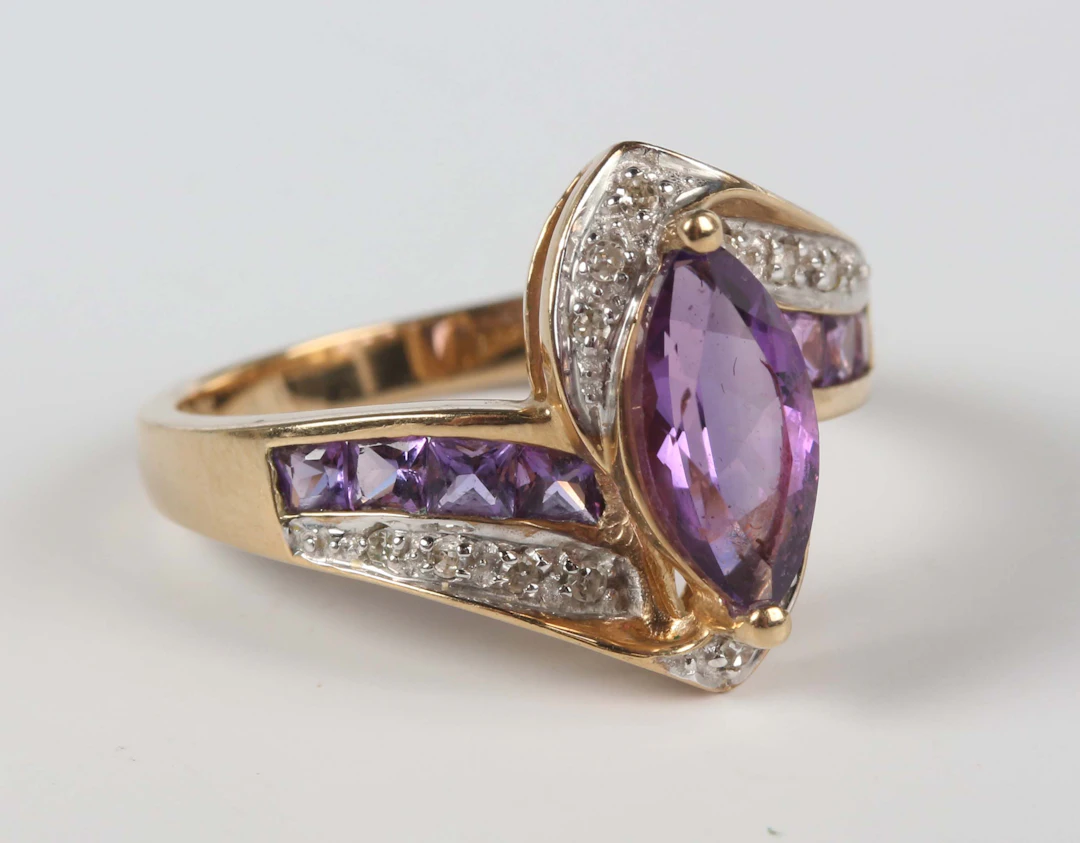 A 9ct gold ring, mounted with a marquise shaped amethyst at the centre
