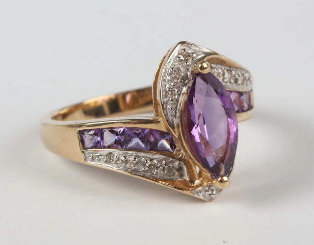 A 9ct gold ring, mounted with a marquise shaped amethyst at the centre