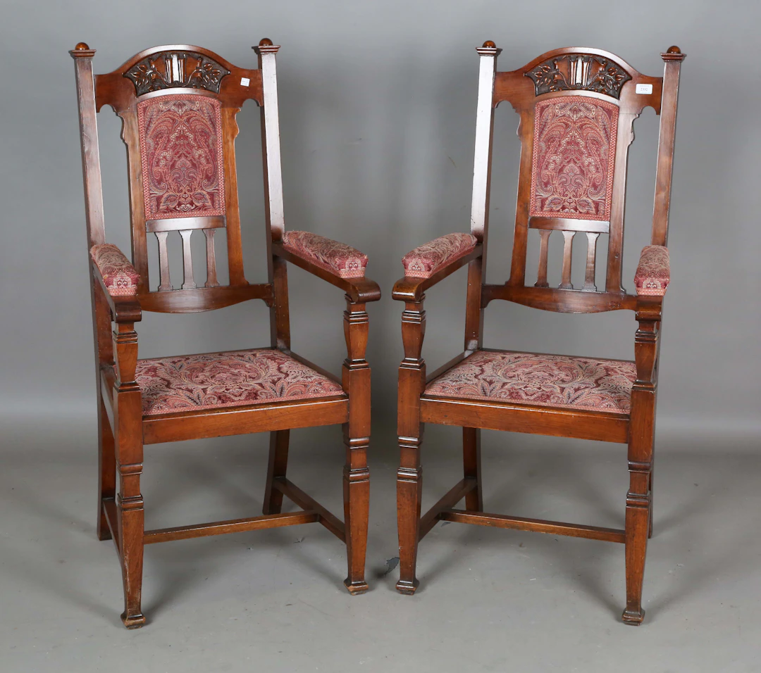 A pair of Edwardian Arts and Crafts walnut framed armchairs, possibly