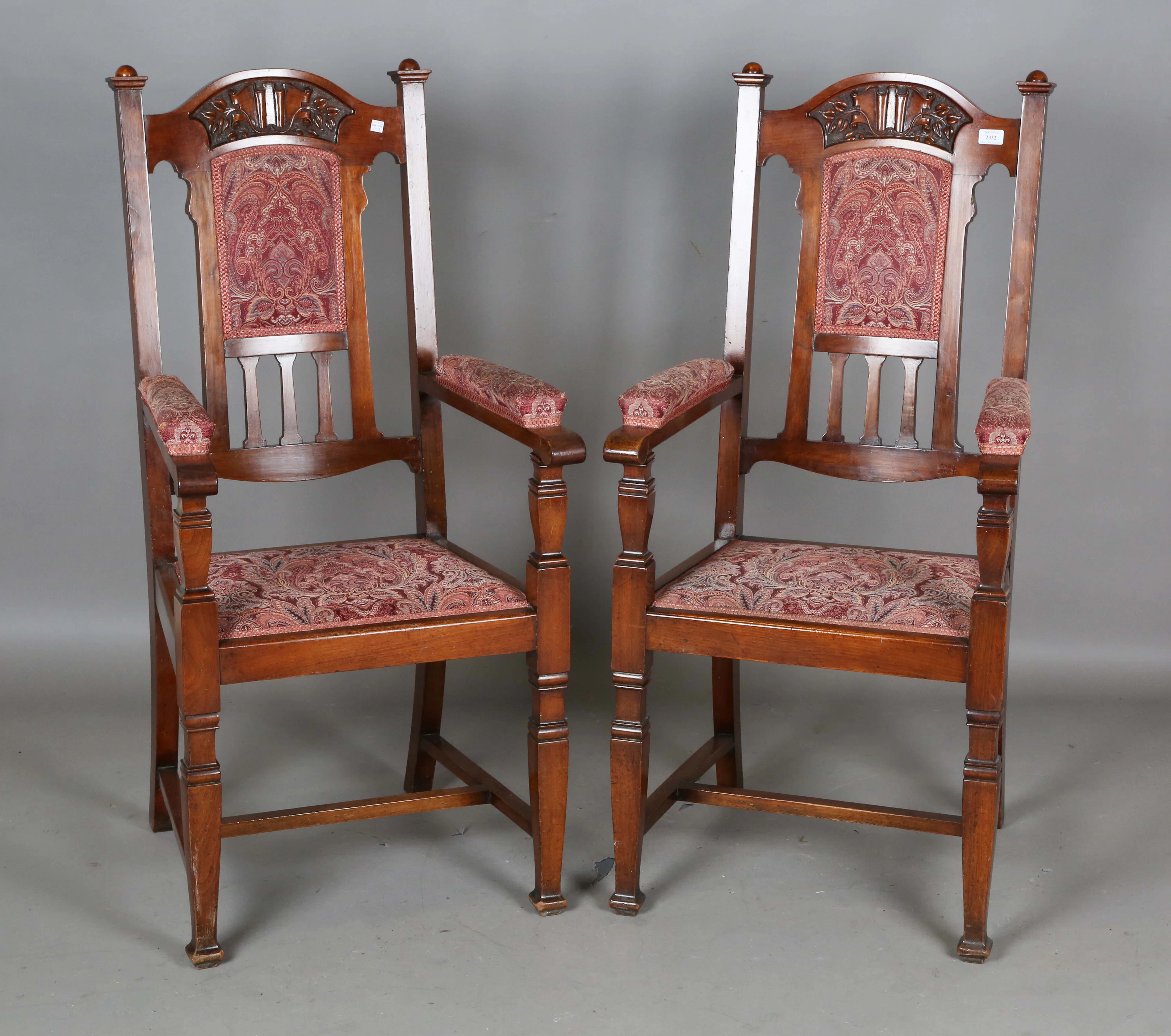 A pair of Edwardian Arts and Crafts walnut framed armchairs, possibly