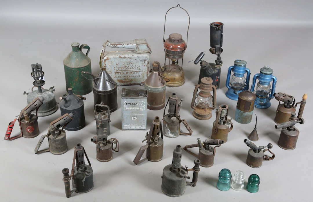 A collection of workshop blow lamps, various tin oil cans and other lamps.