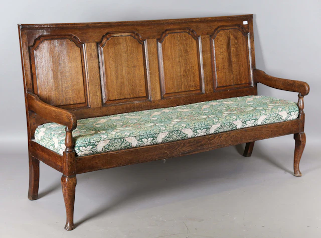 A George III Lancastrian oak settle, the four-panel back flanked by