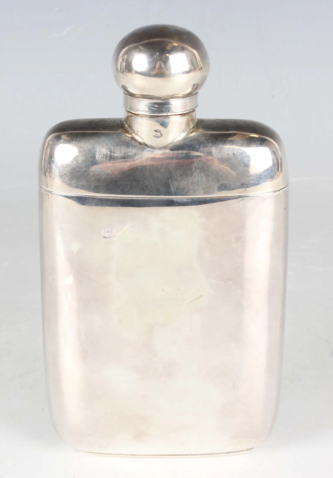 A late Victorian silver hip flask with rotating hinged lid and detachable