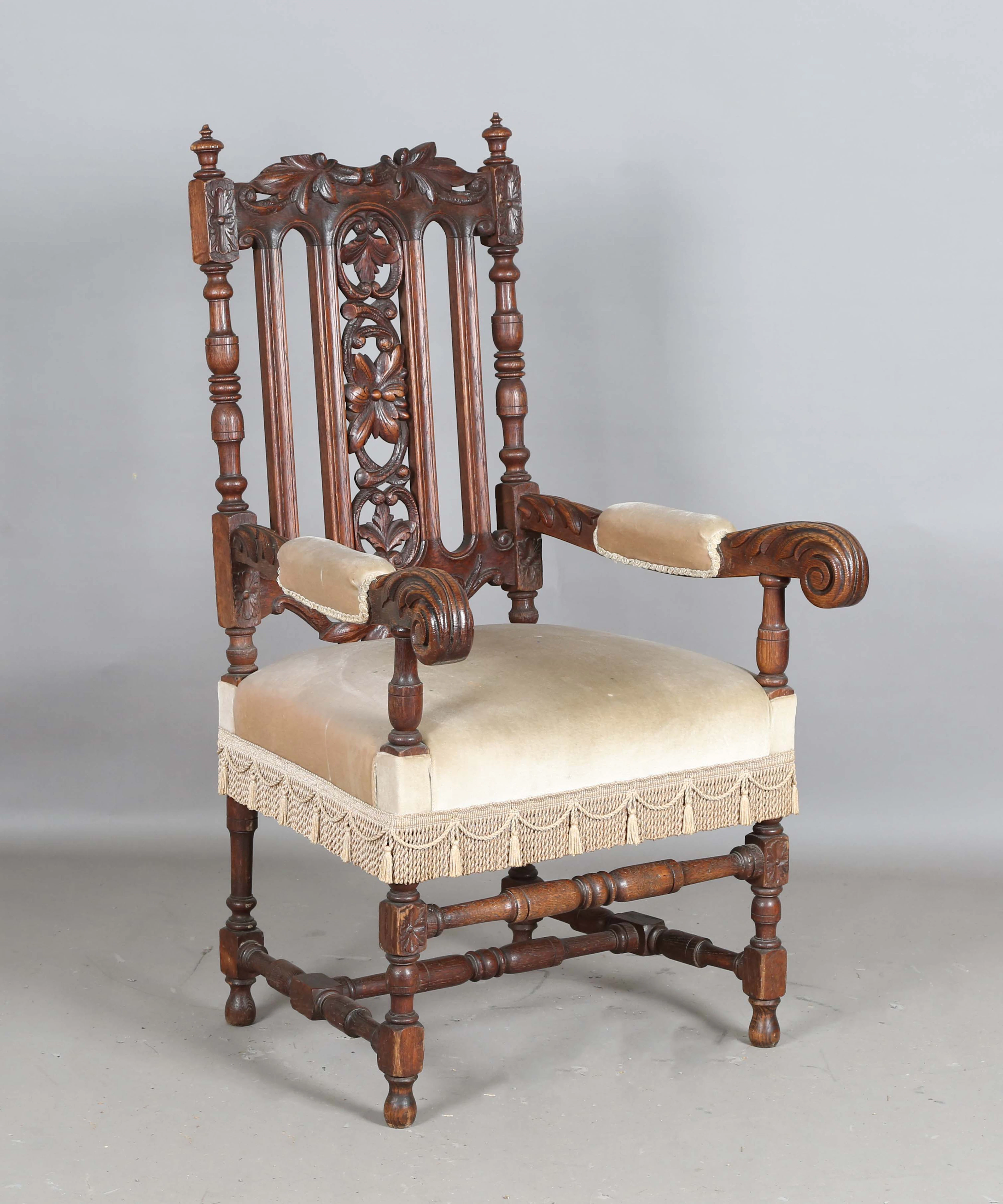 A late Victorian Carolean Revival oak framed armchair with carved