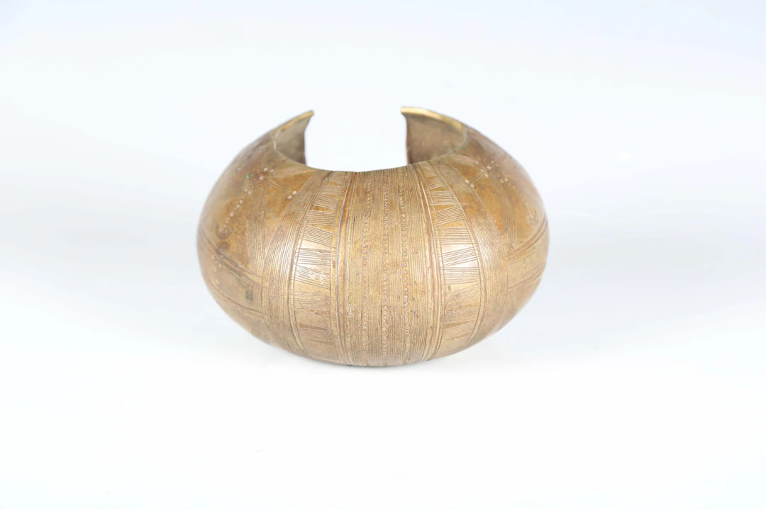 A West African cast bronze currency cuff with overall engraved geometric