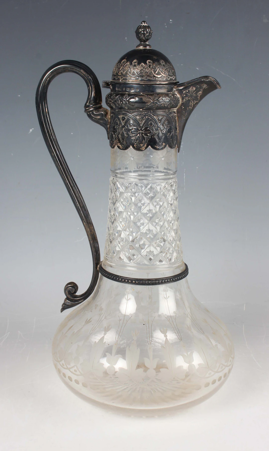 A Victorian silver mounted cut glass claret jug, the domed hinged