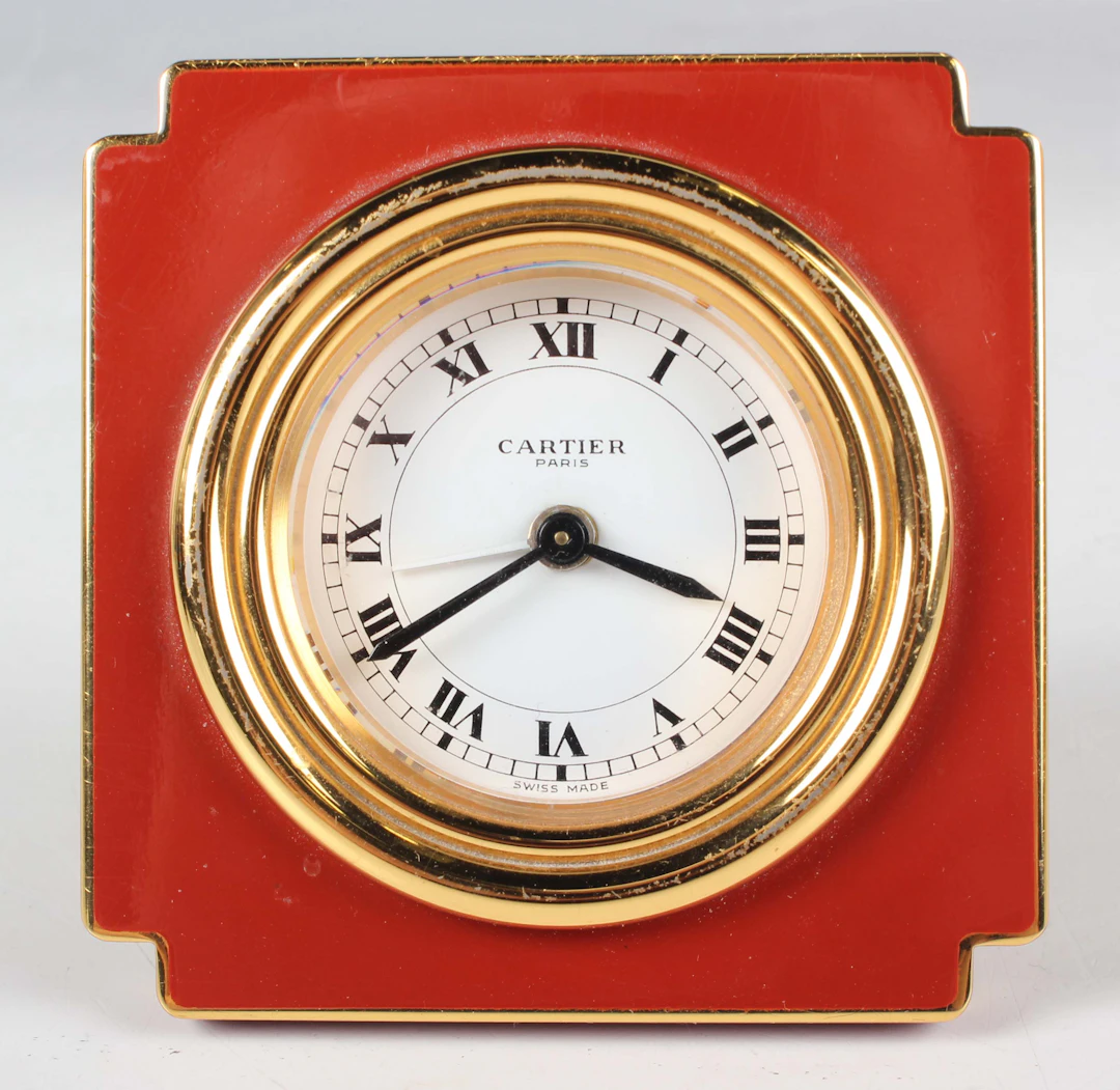 A Cartier Paris gilt brass and iron red enamelled square cased bedside