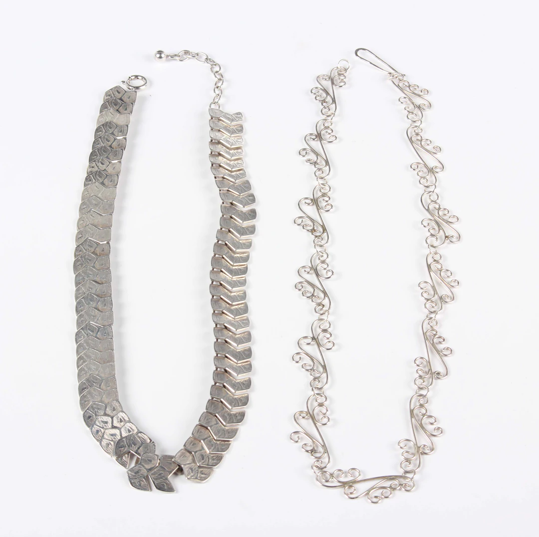 A silver necklace in a scrolling link design, length 41.5cm, and a