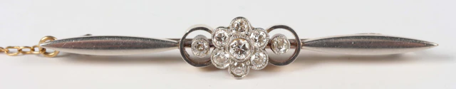 A gold, platinum and diamond bar brooch, designed as a central cluster