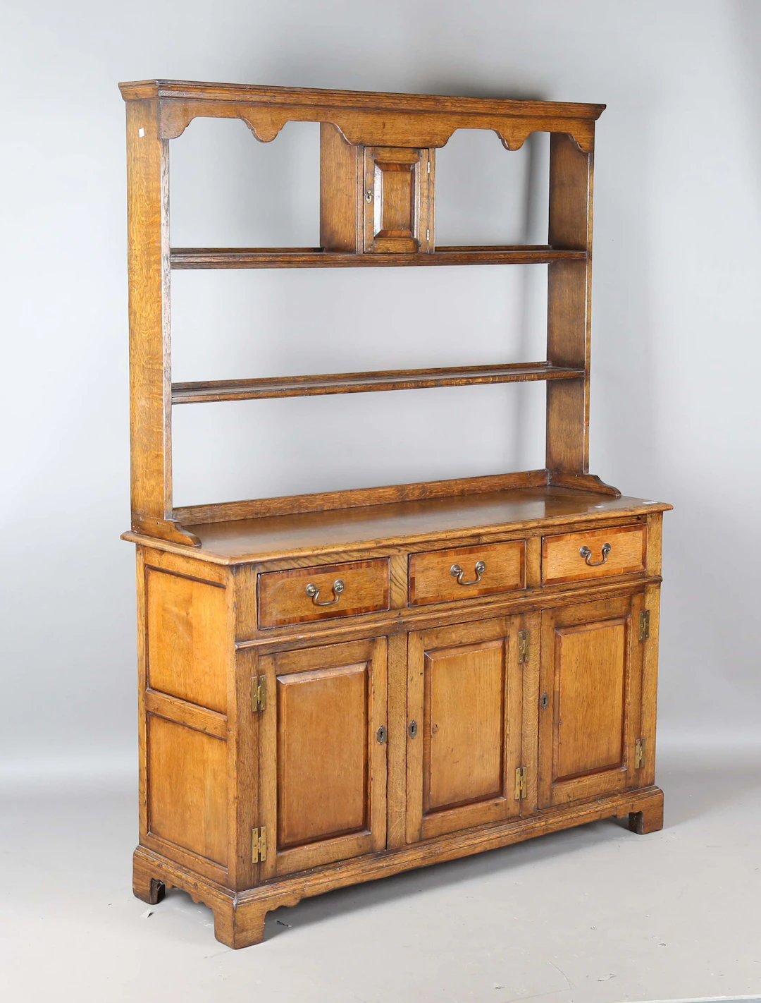 A late 20th century George III style oak dresser with overall crossbanded