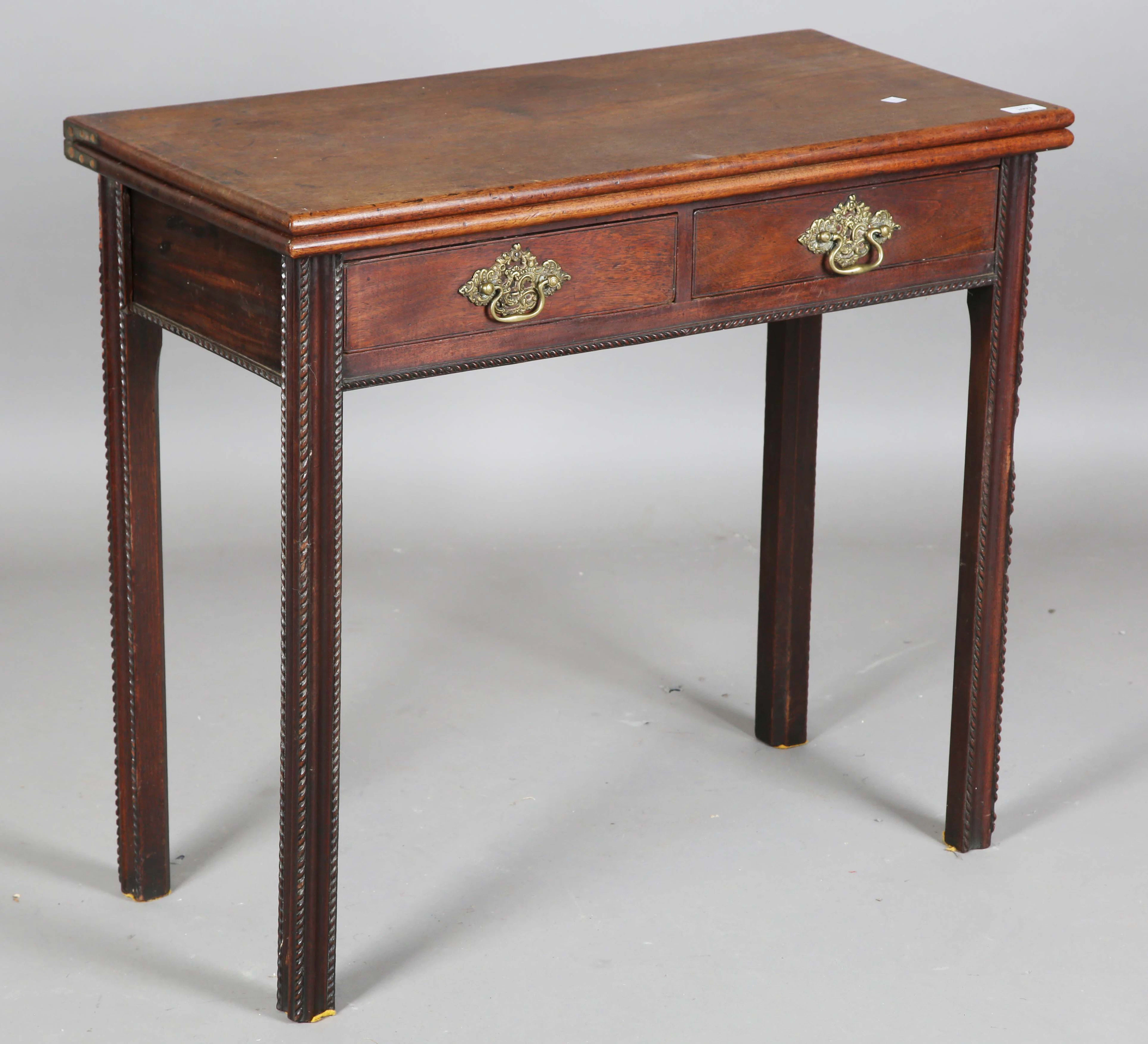 A George III mahogany fold-over tea table, fitted with two frieze