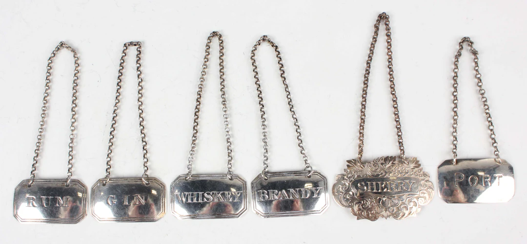 A set of four early Victorian silver decanter labels of canted corner