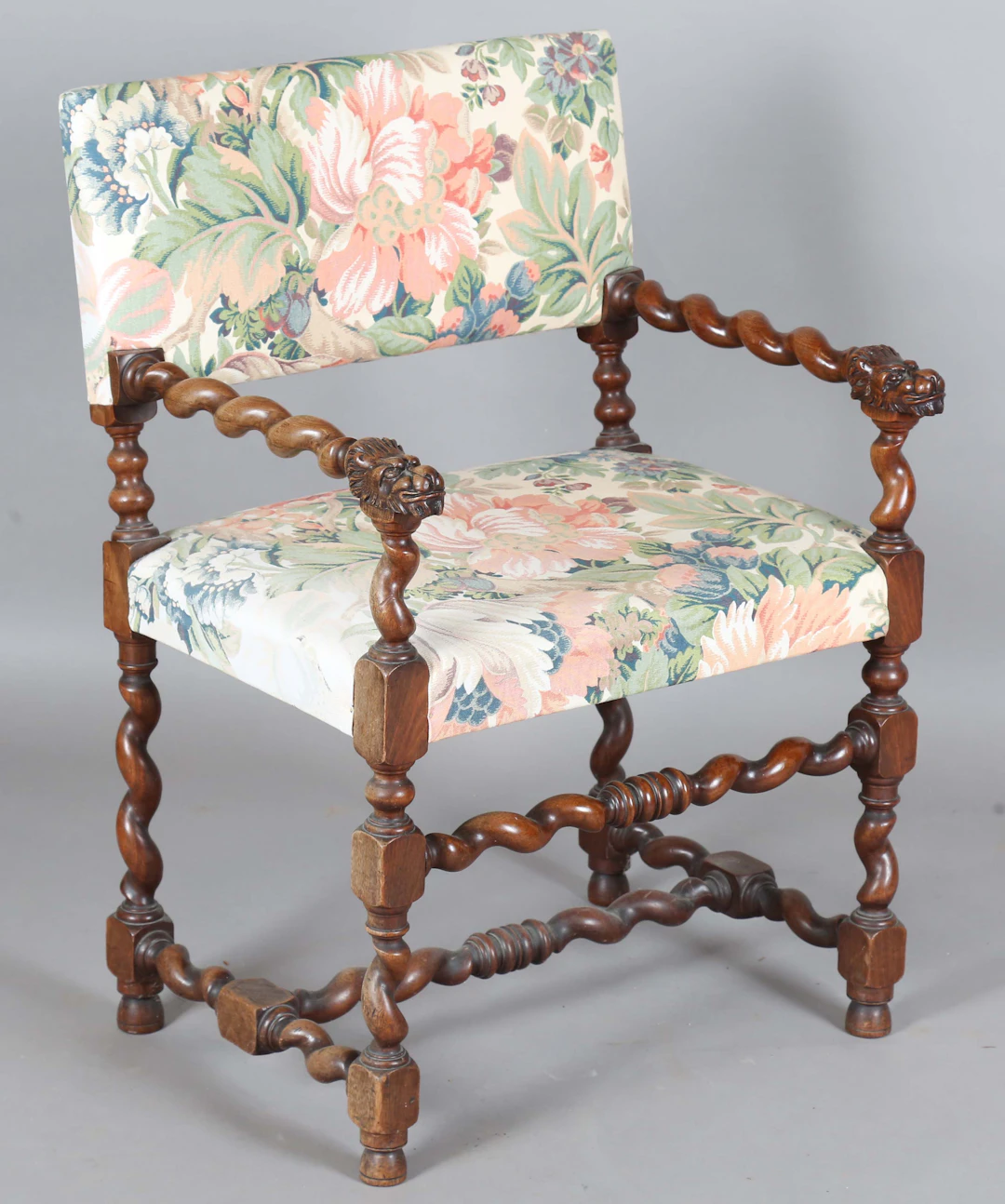An early 20th century walnut framed elbow chair with lion mask handrests