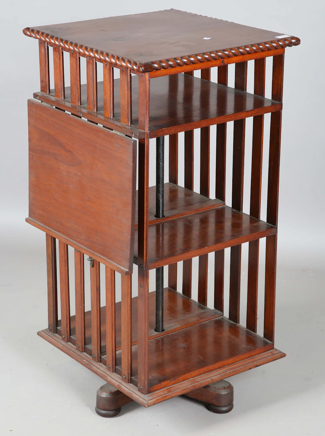 A late Victorian walnut revolving open bookcase, fitted with a hinged