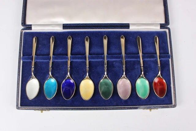 A set of eight Elizabeth II silver gilt and enamelled coffee spoons