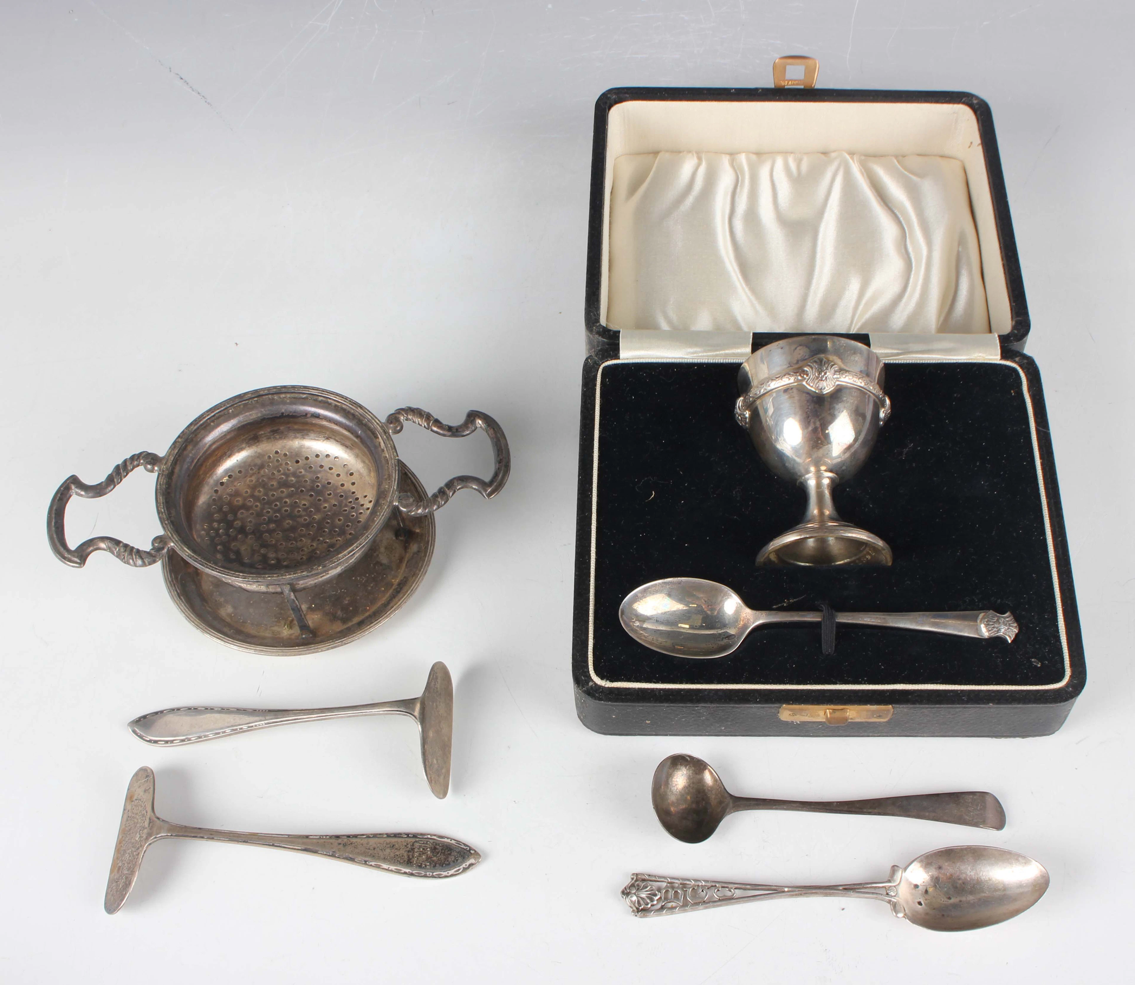 A George V silver christening egg cup and spoon, cast with Celtic