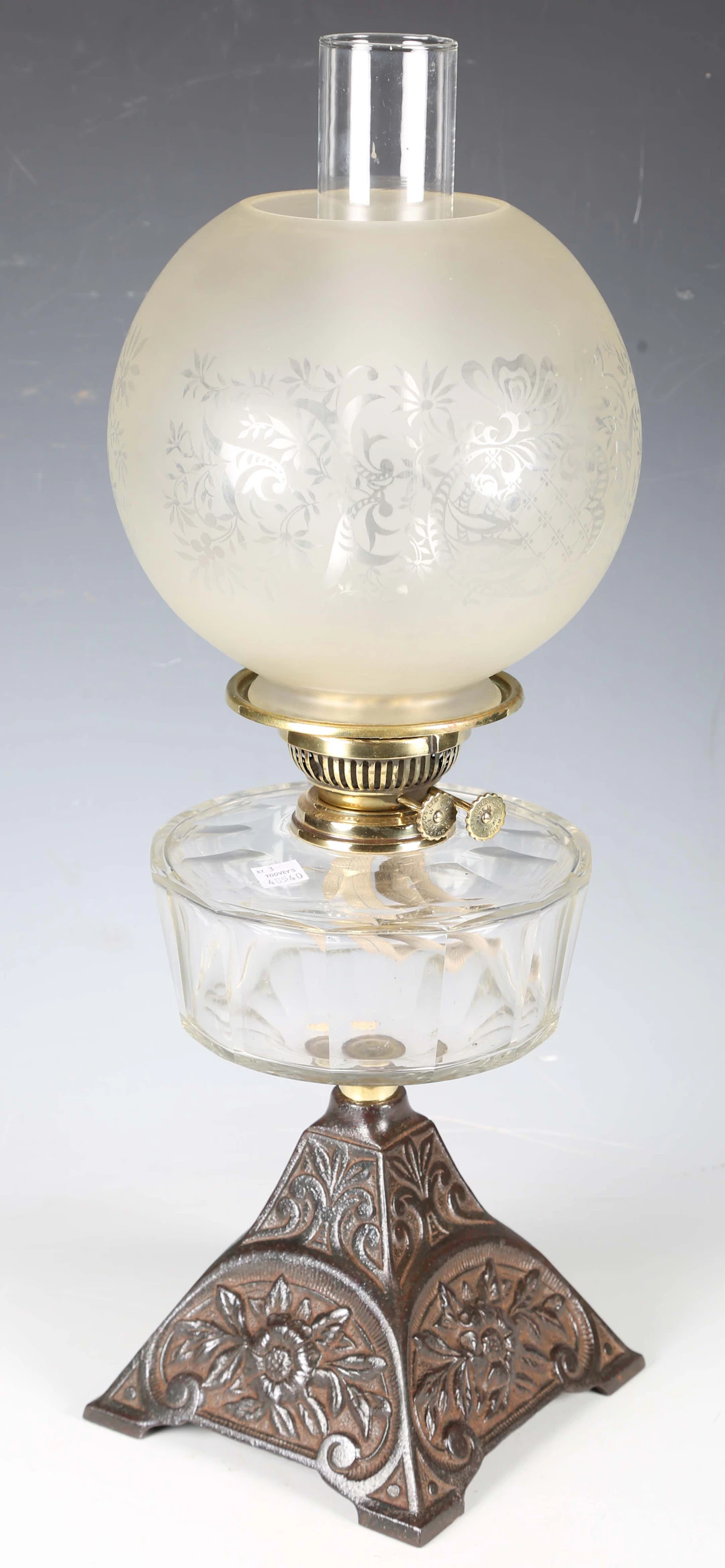 A late Victorian cast metal and clear glass table oil lamp with a