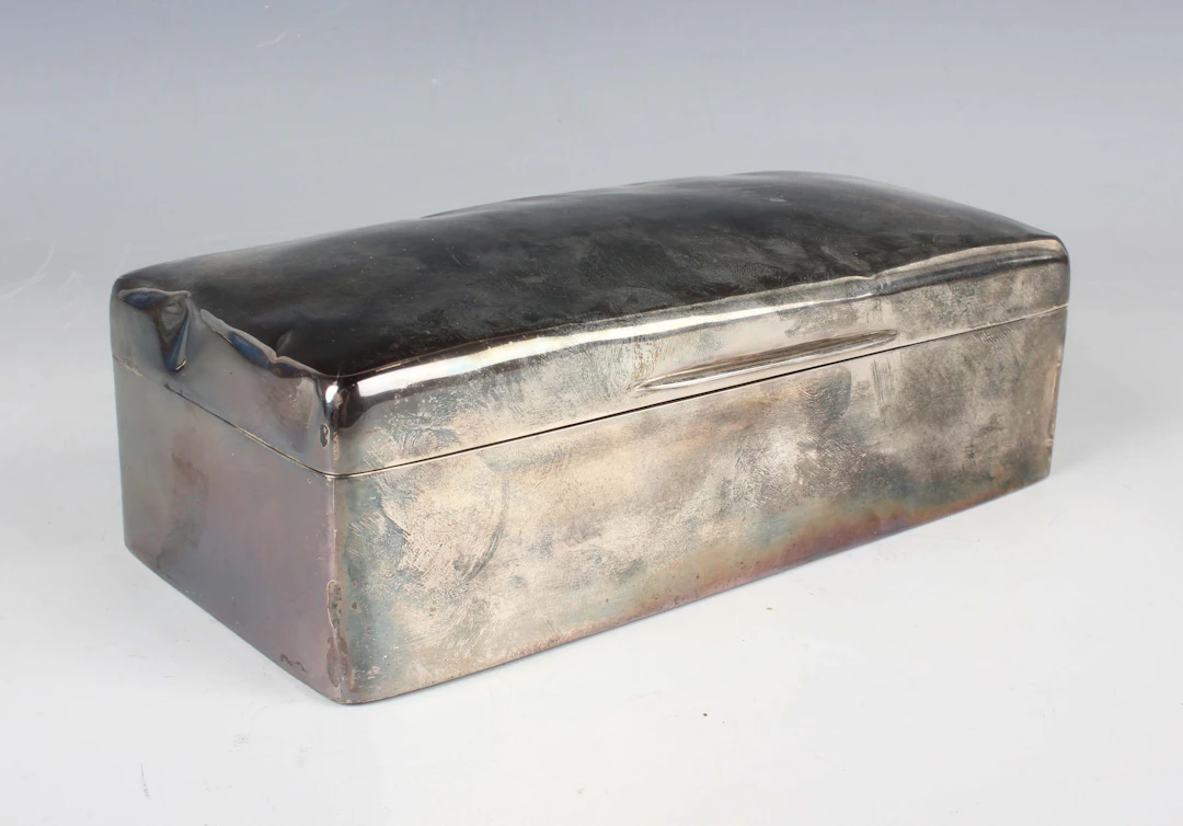 A George V silver rectangular cigarette box with slightly domed hinged
