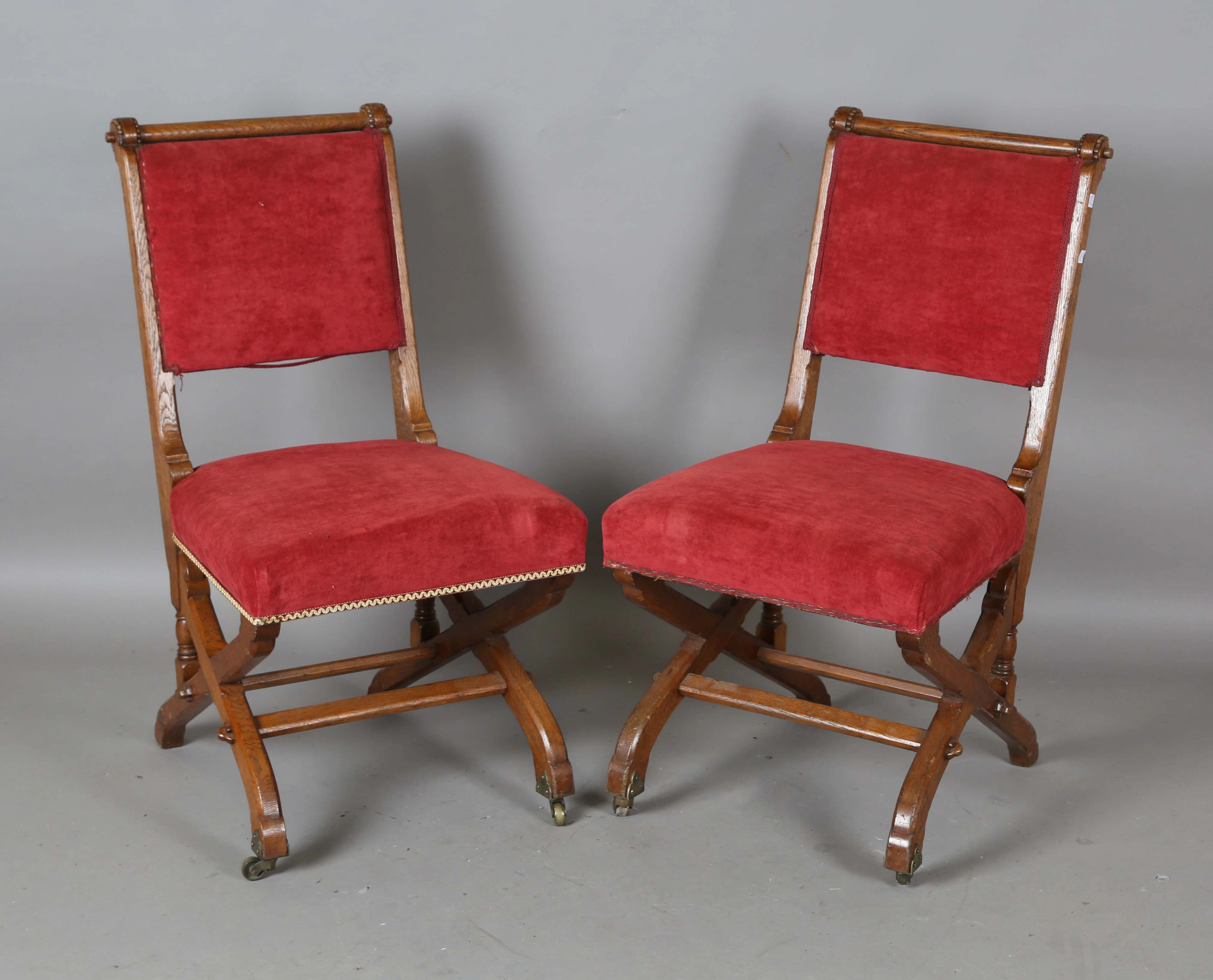 A pair of late Victorian Gothic Revival oak framed side chairs by