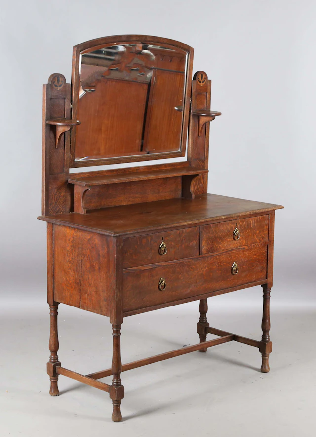 An Edwardian Arts and Crafts oak dressing table with inlaid foliate